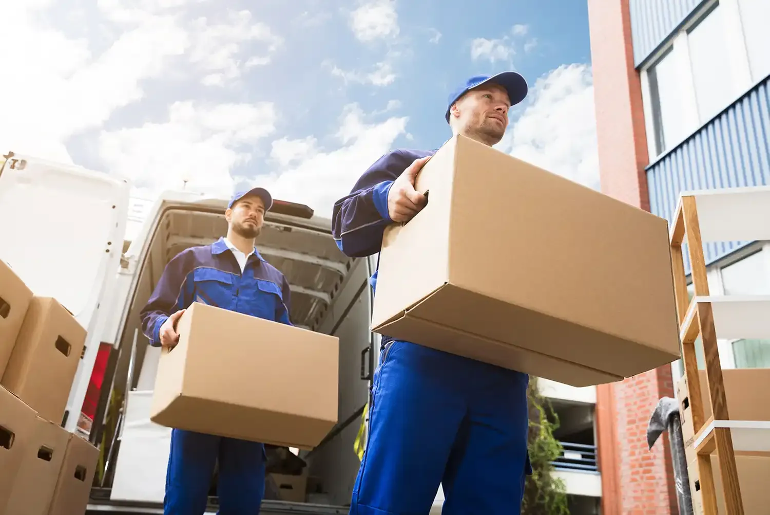 URS GmbH – Transport- und Kurierdienst – Nahaufnahme von zwei Lieferanten mit einem Karton